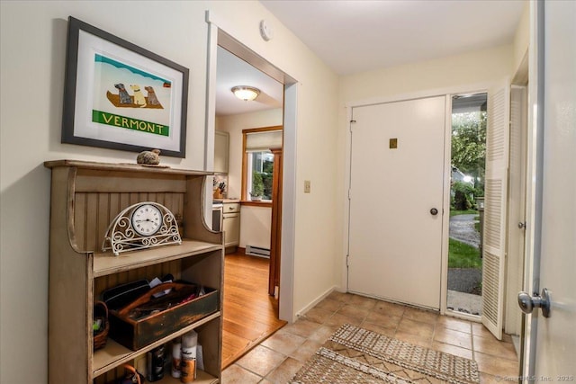 doorway to outside featuring healthy amount of natural light and a baseboard radiator