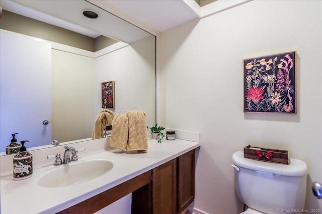 half bathroom featuring vanity and toilet
