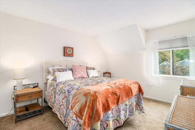 carpeted bedroom featuring baseboards and lofted ceiling