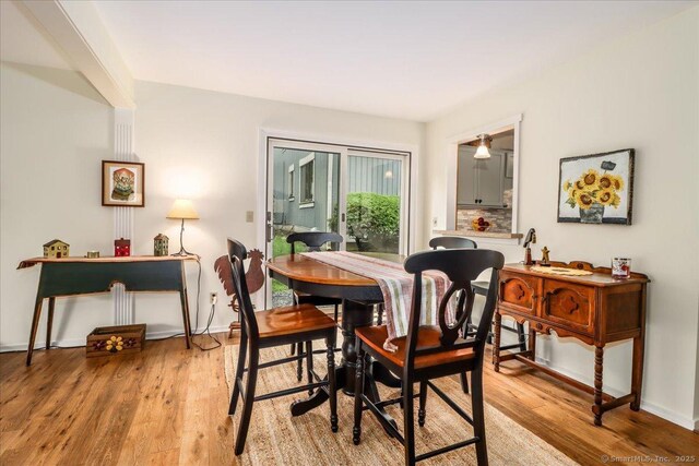 dining space with light wood-type flooring and baseboards