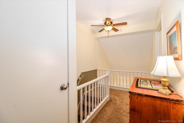 hallway featuring an upstairs landing and carpet