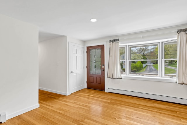 foyer entrance featuring baseboards, light wood-style floors, baseboard heating, recessed lighting, and a baseboard radiator