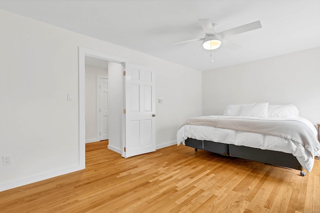 bedroom with baseboards, ceiling fan, and light wood-style floors