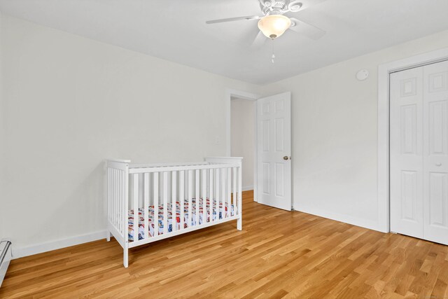bedroom with light wood-type flooring, baseboards, ceiling fan, and a closet
