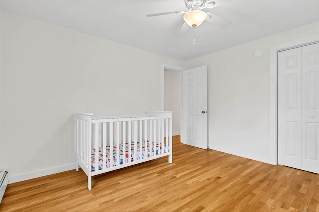7 Old Black Point Rd, East Lyme, CT 06357 - bedroom with light wood-style floors, a closet, a ceiling fan, and a baseboard radiator