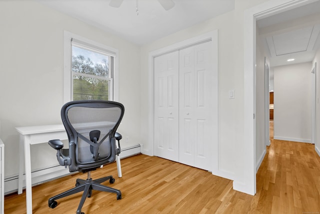 office area featuring attic access, a ceiling fan, light wood finished floors, and a baseboard radiator