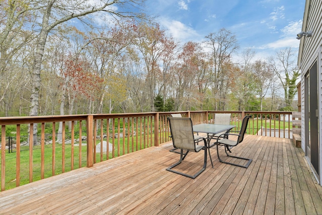 wooden deck featuring outdoor dining space and a yard