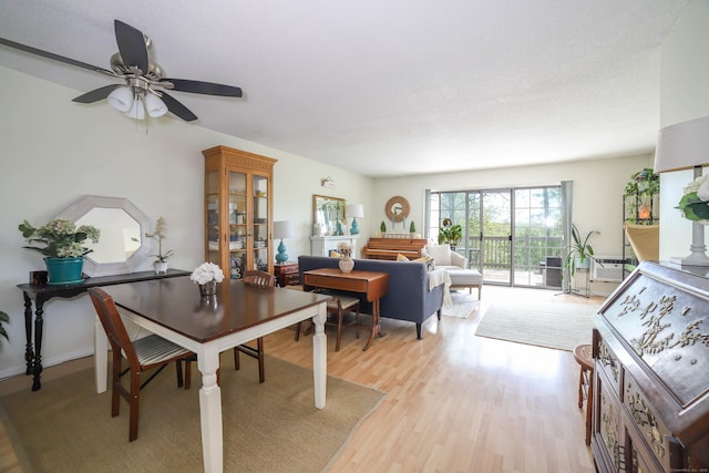 dining space with light wood-style floors and ceiling fan