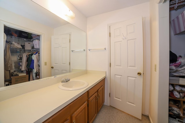 bathroom with vanity and a spacious closet