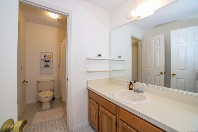 full bath with toilet, tile patterned flooring, vanity, and baseboards