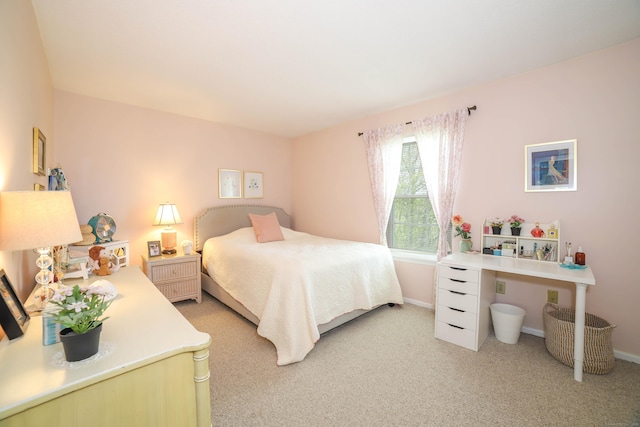 bedroom with light colored carpet and baseboards
