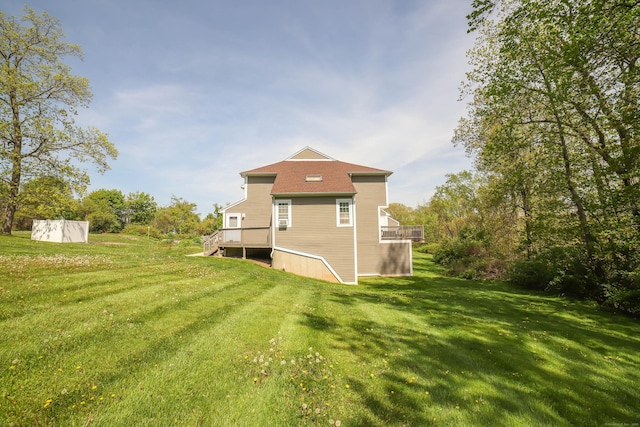rear view of property featuring a lawn and a wooden deck
