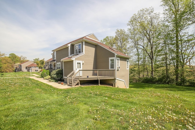 rear view of property with a wooden deck and a lawn
