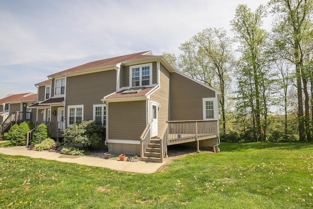 back of house featuring a lawn, a wooden deck, and stairs