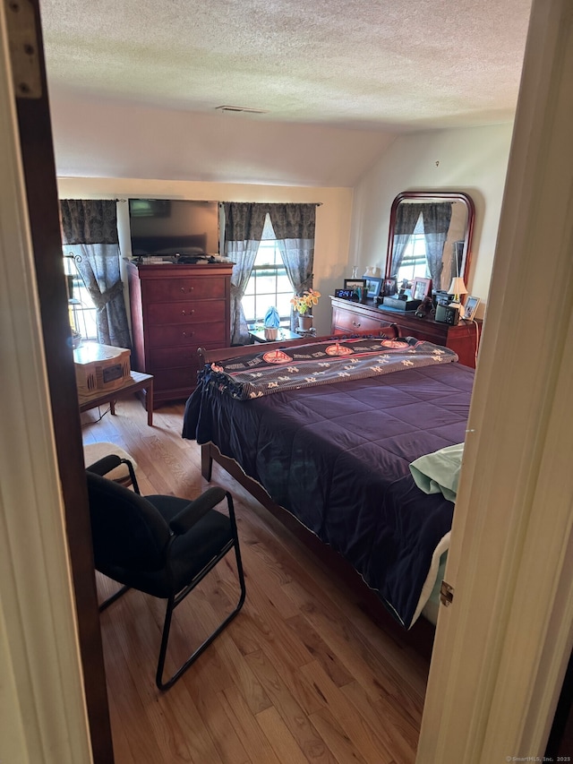 bedroom featuring a textured ceiling and wood finished floors