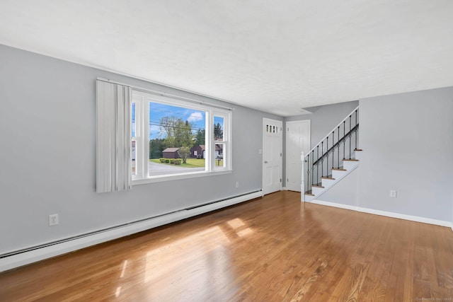 327 Abbe Rd, Enfield, CT 06082 - unfurnished living room featuring baseboards, baseboard heating, stairs, and wood finished floors