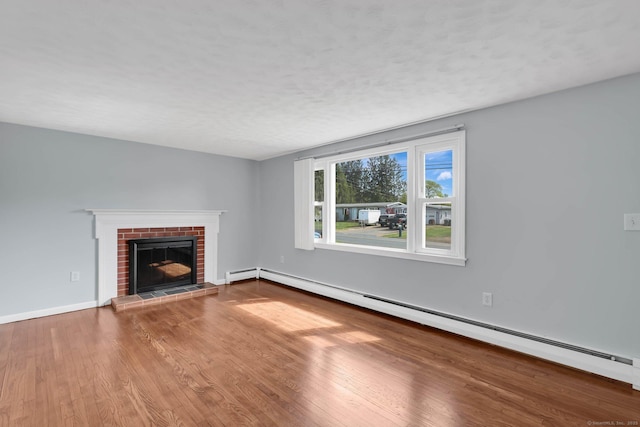 327 Abbe Rd, Enfield, CT 06082 - unfurnished living room featuring baseboards, a baseboard radiator, a brick fireplace, and wood finished floors