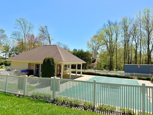 pool with a patio area and fence