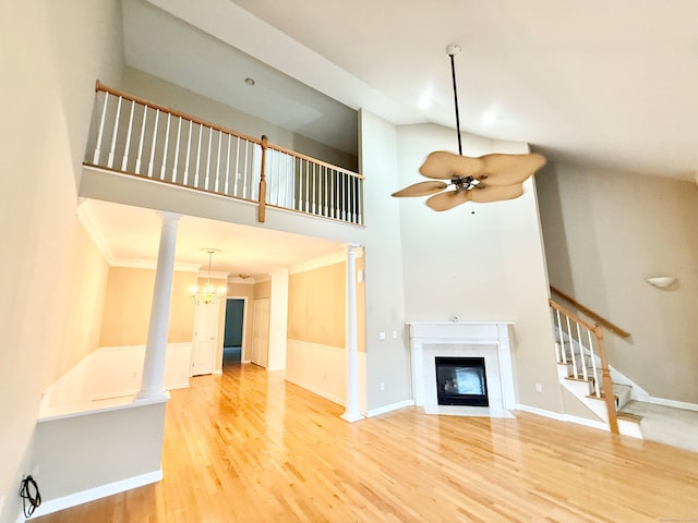 253 Summerfield Gdns Unit 253, Shelton, CT 06484 - unfurnished living room featuring stairs, a fireplace with flush hearth, ceiling fan, decorative columns, and wood finished floors