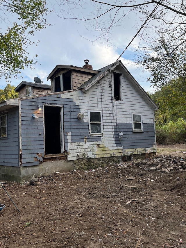 back of property featuring a chimney and entry steps