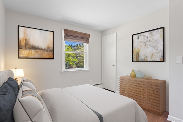 128 W Ave, Darien, CT 06820 - bedroom with wood finished floors, baseboards, and a baseboard heating unit
