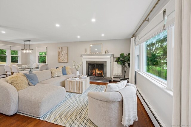 128 W Ave, Darien, CT 06820 - living room with wood finished floors, a fireplace, baseboard heating, recessed lighting, and a chandelier