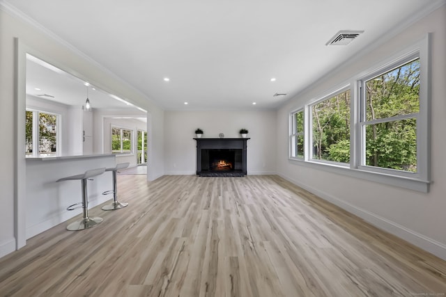 unfurnished living room featuring light wood-type flooring, baseboards, a warm lit fireplace, and recessed lighting