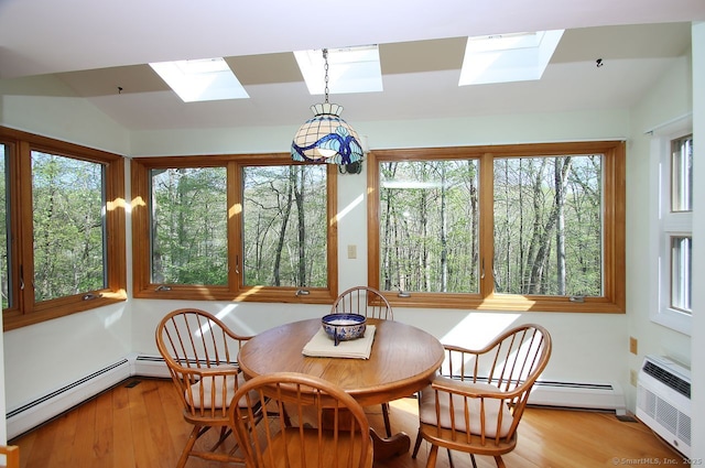 sunroom featuring a skylight, a baseboard heating unit, a wall unit AC, and wood finished floors