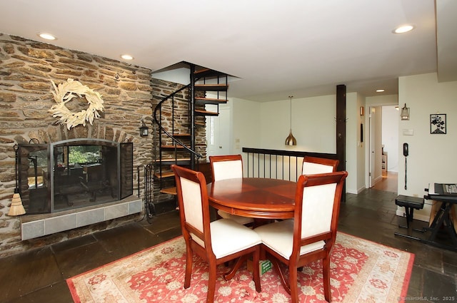 dining room with a stone fireplace, recessed lighting, baseboards, and stairway