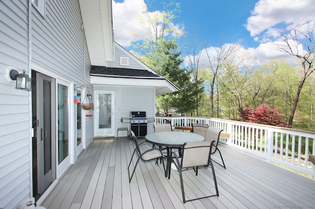 wooden deck with outdoor dining area and a grill