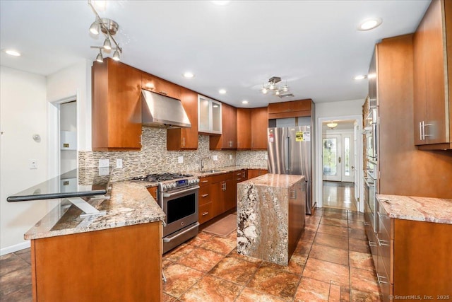 110 Deer Hill Ave, Danbury, CT 06810 - kitchen featuring stainless steel appliances, under cabinet range hood, brown cabinets, tasteful backsplash, and recessed lighting
