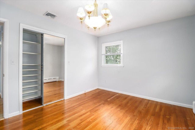 110 Deer Hill Ave, Danbury, CT 06810 - unfurnished bedroom featuring a baseboard heating unit, a chandelier, light wood-style flooring, a closet, and baseboards