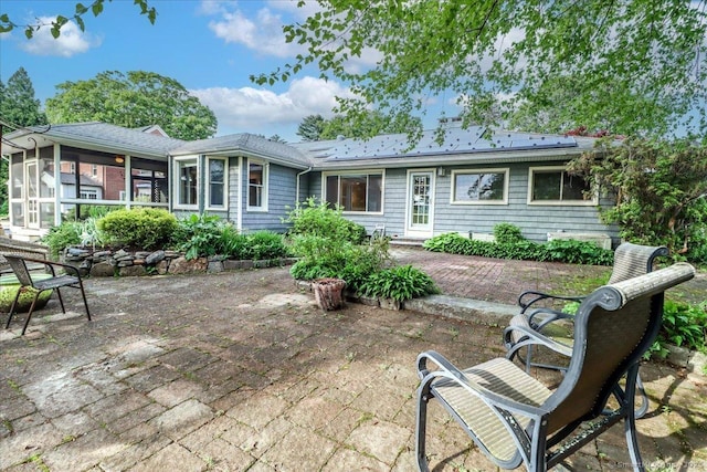 110 Deer Hill Ave, Danbury, CT 06810 - back of house featuring a sunroom, a patio area, and solar panels