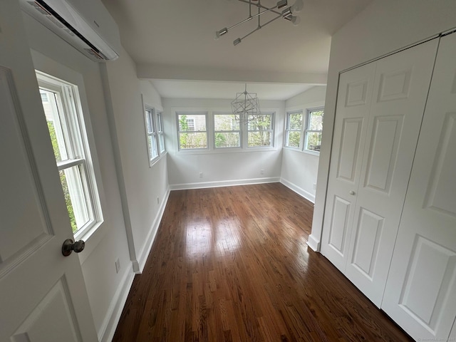 14 Sherman St, Stamford, CT 06902 - unfurnished dining area with a chandelier, a wall mounted AC, dark wood finished floors, baseboards, and lofted ceiling