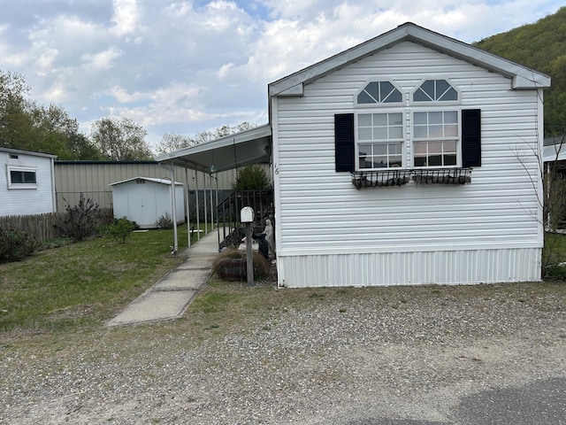 view of front of house featuring a storage unit, an outbuilding, and a carport
