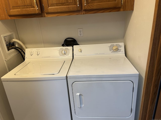 laundry room featuring washer and clothes dryer and cabinet space