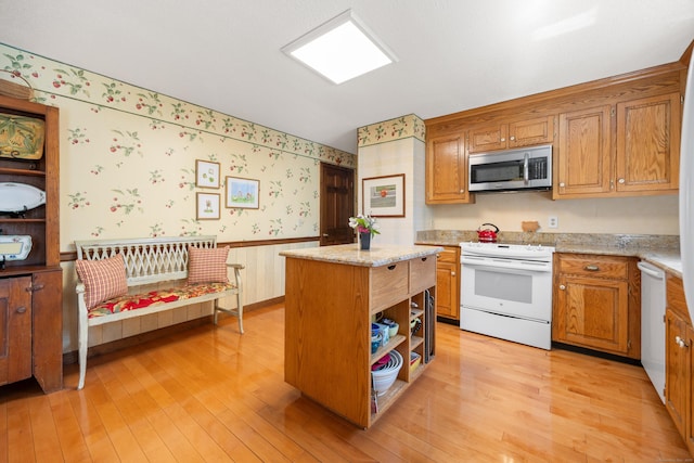 7 Partridge Ln, Burlington, CT 06013 - kitchen with white appliances, wallpapered walls, a wainscoted wall, light wood-style flooring, and a center island
