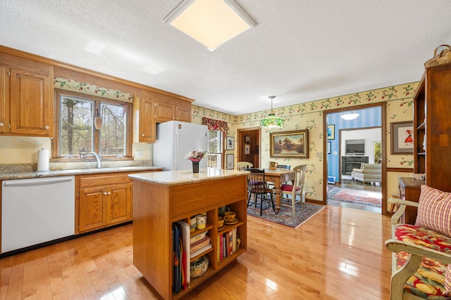 7 Partridge Ln, Burlington, CT 06013 - kitchen featuring white appliances, wallpapered walls, light wood-style floors, a textured ceiling, and a kitchen island