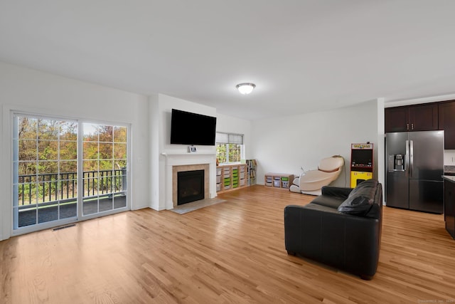 living area with light wood-style flooring and a fireplace with flush hearth