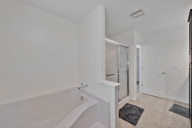 bathroom featuring a garden tub, a shower stall, tile patterned flooring, and baseboards