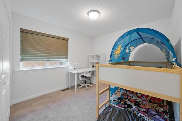 bedroom featuring carpet floors, baseboards, and a textured ceiling
