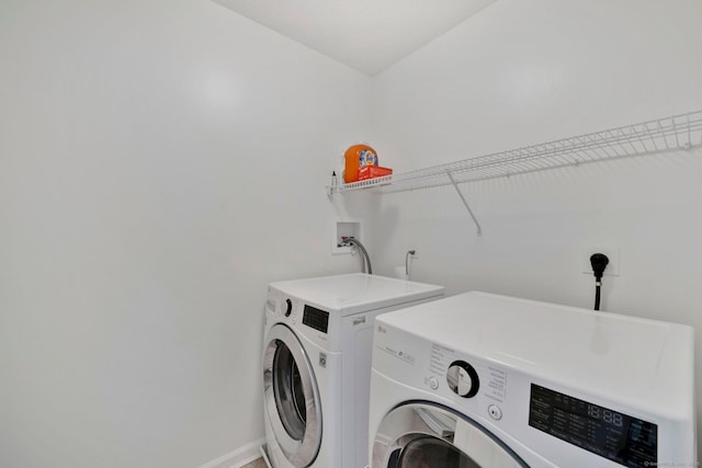 laundry area with separate washer and dryer and baseboards