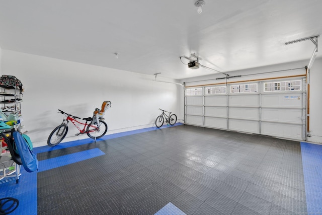 garage featuring a garage door opener and baseboards