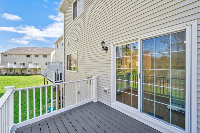 wooden deck with a residential view and a lawn