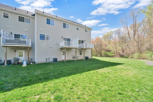 back of property featuring central AC unit and a yard