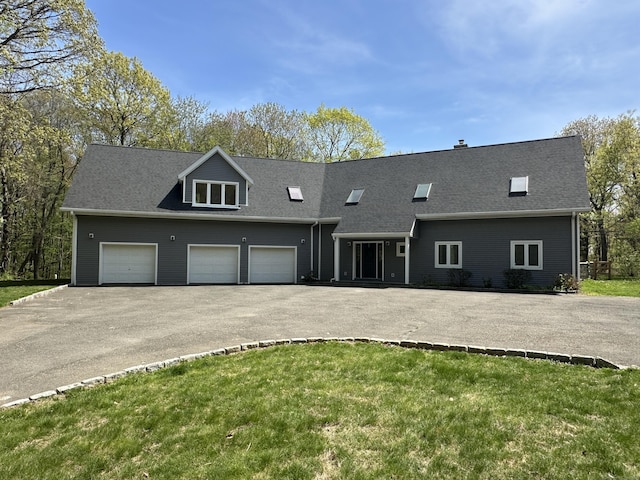 view of front of house with roof with shingles, a garage, a front yard, and aphalt driveway
