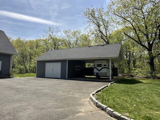 garage with driveway and an attached carport