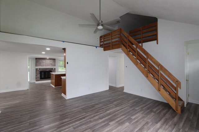 340 Robbins Ave, Newington, CT 06111 - unfurnished living room with ceiling fan, dark wood-style flooring, a fireplace, high vaulted ceiling, and stairs