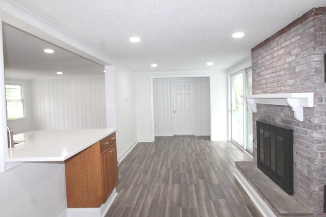 340 Robbins Ave, Newington, CT 06111 - unfurnished living room with baseboards, recessed lighting, dark wood finished floors, and a brick fireplace