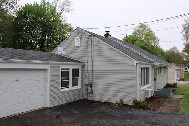 340 Robbins Ave, Newington, CT 06111 - view of home's exterior featuring an attached garage, a shingled roof, and a chimney